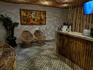 a room with two chairs and a counter with a picture on the wall at Hotel Casa Bamboo in Valladolid
