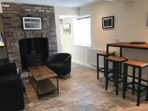 a living room with a fireplace and a table and chairs at Bettws Hall Accommodation in Newtown