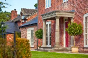 a red brick house with a red door at Bettws Hall Accommodation in Newtown