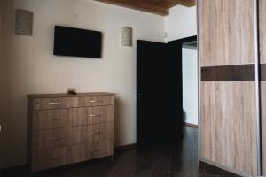 ein Schlafzimmer mit einer Kommode und einem TV an der Wand in der Unterkunft Relax in Dobrinischte
