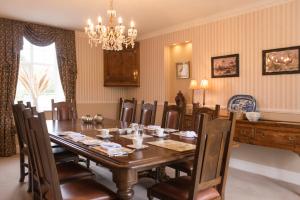 a dining room with a wooden table and chairs at Bettws Hall Accommodation in Newtown