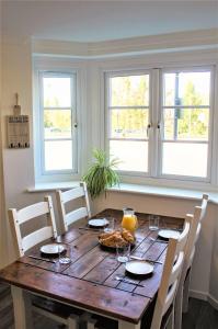 a dining room table with chairs and two windows at Meadow View in Stamford