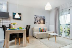 a living room with a table and a couch at Apartments Warsaw Obozowa by Renters in Warsaw