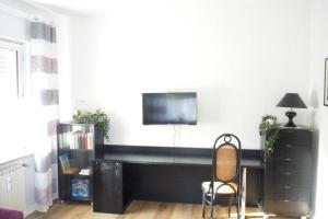 a living room with a tv and a chair at Schlafen vor den Toren von Osnabrück für 5 Pers. in Atter +2 photos