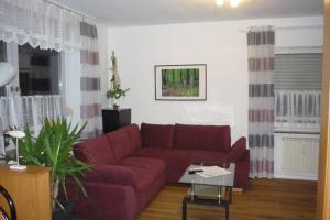 a living room with a red couch and a table at Schlafen vor den Toren von Osnabrück für 5 Pers. in Atter