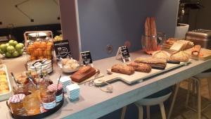 une table avec différents types de pain et autres denrées alimentaires dans l'établissement Mercure Beauvais Centre Cathédrale, à Beauvais