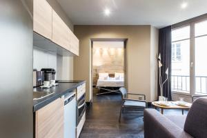 uma cozinha com um balcão e uma sala de estar em CMG Suite Deluxe- 44 em Paris