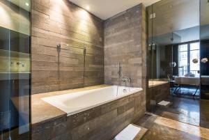 uma casa de banho com uma banheira, um chuveiro e um lavatório. em CMG Suite Deluxe- 44 em Paris
