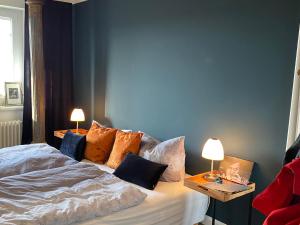 1 dormitorio con 1 cama con almohadas y 2 lámparas en Kliffssand 33, en Kampen