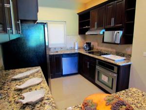 a kitchen with a black refrigerator and a counter at Tamarindo Condo 206 Matapalo in Tamarindo