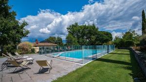 una piscina con sillas y una valla alrededor en Poggio alle Fonti 11, en Montevarchi