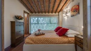 Un dormitorio con una cama con almohadas rojas y una ventana. en Poggio alle Fonti 11, en Montevarchi 41 fotos más
