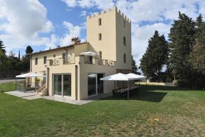 una casa grande con una torre en la cima de un campo en Villa La Torre 16, en Montespertoli