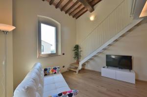 Una sala de estar con un sofá y un televisor. en Villa La Torre 16, en Montespertoli