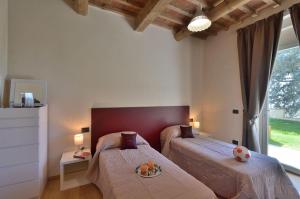 Un dormitorio con dos camas y una gran ventana. en Villa La Torre 16, en Montespertoli 40 fotos más