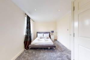 a white bedroom with a bed and a window at Super 2 bed House wPrivateParking&PrivateGarden in London