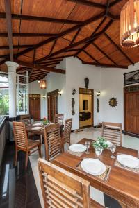 a dining room with wooden tables and chairs at Avon Villa in Hikkaduwa