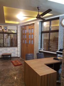 Habitación con ventilador de techo y escritorio con sillas. en K K RENUKA DHARAMSHALA, en Haridwar