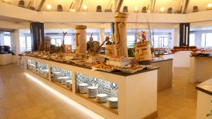 a buffet line with food on display in a store at Club Esse Cala Bitta in Baja Sardinia