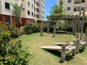a park with benches in front of a building at Apartamento Aruana a 3 Km da praia in Atalaia Velha