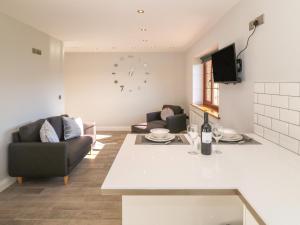 a kitchen and living room with two chairs and a table at Afon Rhos Bach in Caernarfon