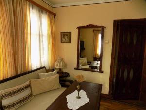 sala de estar con sofá y espejo en Dona Guest House - Horse Riding en Koprivshtitsa