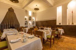 Riad Amin في مراكش: غرفة طعام مع طاولات وكراسي بيضاء