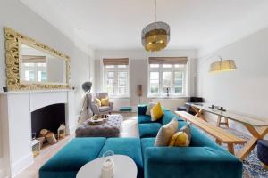 a living room with a blue couch and a table at Modern 2 Bed Flat - The Black Dog Pub APT - 6 mins from Vauxhall station in London