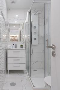 La salle de bains blanche est pourvue d'une douche et d'un lavabo. dans l'établissement OportoHost Dragão Duplex, à Porto