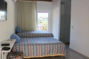 um quarto de hotel com duas camas e uma janela em Solar Água Pipa #260 - Apê na Praia por Carpediem em Pipa
