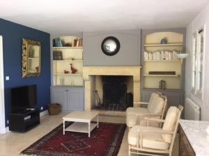 a living room with two chairs and a fireplace at Dans la bastide de Domme - piscine chauffée, parking privé in Domme