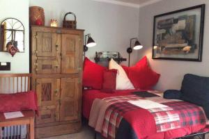 - une chambre avec un lit rouge et une armoire en bois dans l'établissement Quiet Private Studio with Pool for One Guest, à Lake Worth