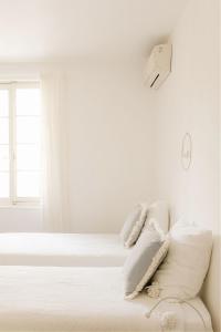 a white bedroom with white sheets and pillows on a bed at 7 en Arles in Arles