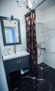 W łazience znajduje się umywalka i lustro. w obiekcie Small paradise by the old bridge w Chalkidzie