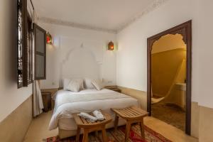 sypialnia z łóżkiem, 2 krzesłami i lustrem w obiekcie Riad Amin w Marakeszu