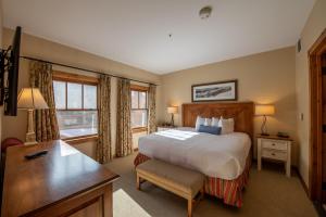 a bedroom with a large bed and a desk and a desk at Kid-Friendly 2 bedroom 3 bathroom condo - Slopeside condo in Crested Butte +16 photos