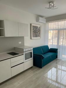 ein Wohnzimmer mit einer blauen Couch in einer Küche in der Unterkunft CASA VITTORIA - SIEGESHAUS in Bozen