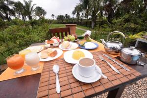 a picnic table with breakfast foods and drinks on it at Encantes do Nordeste in Barreirinhas
