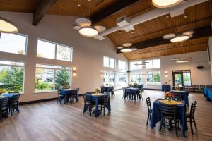 una sala da pranzo con tavoli e sedie blu e finestre di Gateway Hotel a Seward