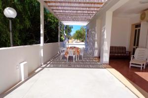 un porche con mesa y sillas en Villetta indipendente con giardino 400m dal mare Rif. 448, en Leuca