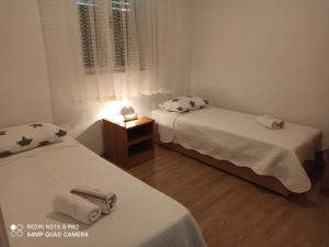 um quarto com duas camas e um candeeiro sobre uma mesa em Apartment Kosor em Zaboric