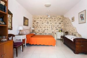 een slaapkamer met 2 bedden en een stenen muur bij Beautiful Holiday House near the sea in Sissi