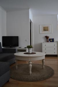 a living room with a coffee table and a tv at Šaulys in Druskininkai