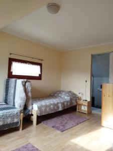 1 dormitorio con cama, sofá y ventana en Naszály Kapuja vendégház, en Kosd