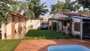 a house with a car parked in the yard at Pousada recantoceccataratas in Foz do Iguaçu