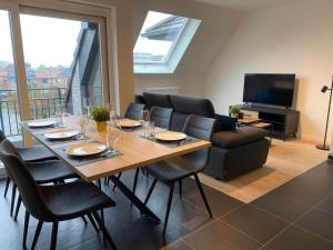 a dining room with a table and chairs and a television at Appartement Anne-Rose in Beernem