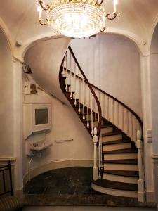 a chandelier hangs over a spiral staircase in a building at JARDIN D'HIVER CASSEL Suite de 70 m2 in Cassel