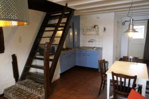 a kitchen with a wooden spiral staircase in a room at Bergerhof de Stal in Sevenum