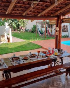 a wooden table with food on top of a patio at Pousada recantoceccataratas in Foz do Iguaçu
