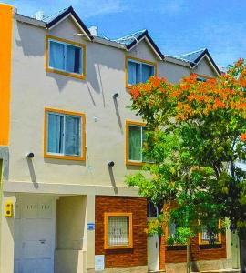 a house with a tree in front of it at ApartHotel Bahia in Neuquén